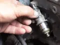 Main tenue un injecteur de carburant, possiblement en raison d'un problème d'injecteur.