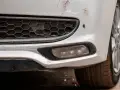 Pare-chocs avant d'une voiture blanche avec des éraflures et des éclats de peinture. Une méthode pour redresser carrosserie eau chaude pourrait aider à réparer ces dommages.