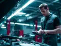 Mécanicien vérifiant une voiture, le voyant batterie s'allume et s'éteint sur son appareil.