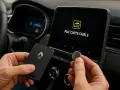 Main gauche tenant une carte Renault, main droite une pile bouton. L'écran affiche "Pile carte faible".