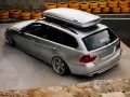 Voiture break argentée avec coffre de toit Thule, prête pour le voyage. La consommation de carburant est une préoccupation, mais le style est au rendez-vous.