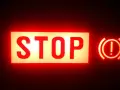 Voyant STOP et symbole de frein à main allumés en rouge. Vérifiez le niveau du liquide de frein.