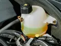 Réservoir de jauge liquide de refroidissement d'une voiture, avec le liquide visible entre les marques MIN et MAX.