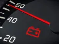 Tableau de bord d'une voiture avec le symbole batterie allumé en rouge, indiquant un problème de charge.