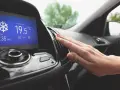 Main d'une personne vérifiant la sortie d'air climatisé dans une voiture, affichant 19.5°C. Parfait pour le clim air chaud.