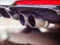 Double sortie d'échappement d'une voiture. La question "peut-on rouler avec un catalyseur défectueux" se pose face à ces gaz d'échappement.