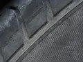 Gros plan sur un pneu craquelé, signe d'usure avancée. Ce pneu craquelé ne passerait pas le contrôle technique.
