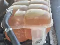 Le réservoir de liquide de refroidissement est plein, indiquant trop de liquide de refroidissement. Les marques MAX et MIN sont visibles.