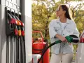 Femme faisant le plein d'essence, inquiète des symptômes de mauvais carburant voiture.