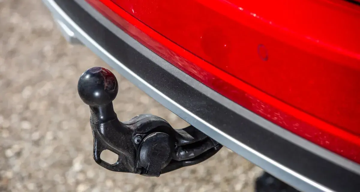 Boule d'attelage sur une voiture rouge, prête pour le remorquage.