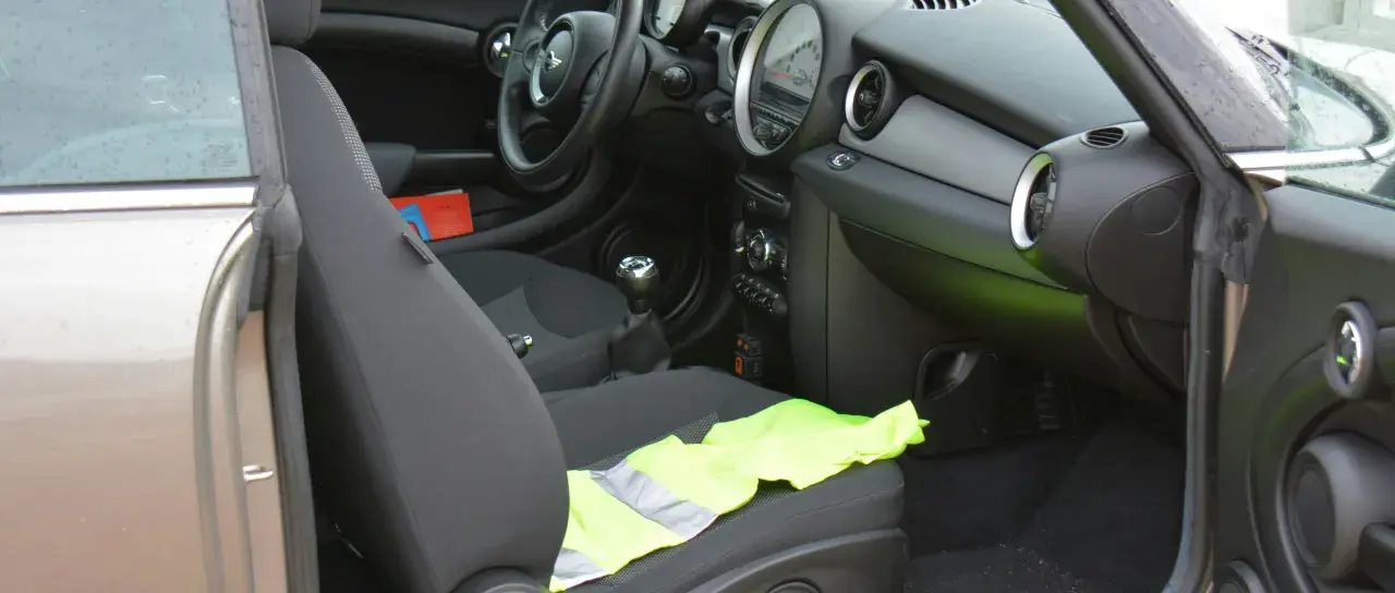 Le gilet jaune est posé sur le siège passager d'une Mini Cooper.