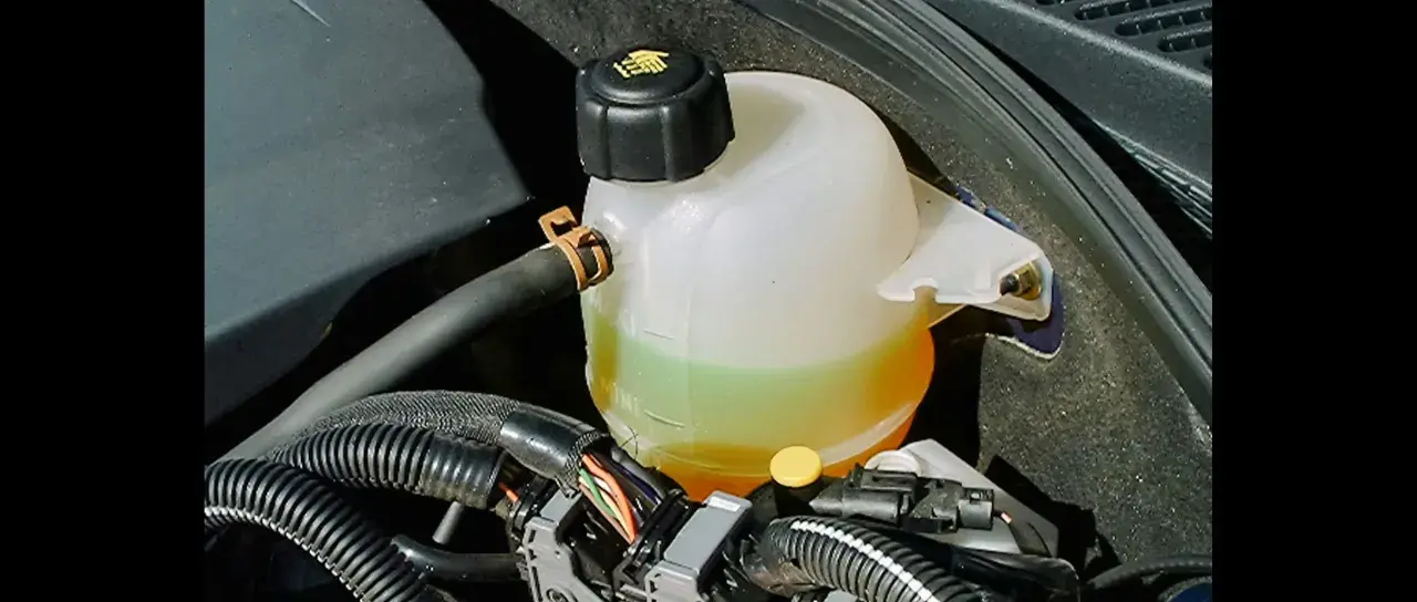 Réservoir de jauge liquide de refroidissement d'une voiture, avec le liquide visible entre les marques MIN et MAX.