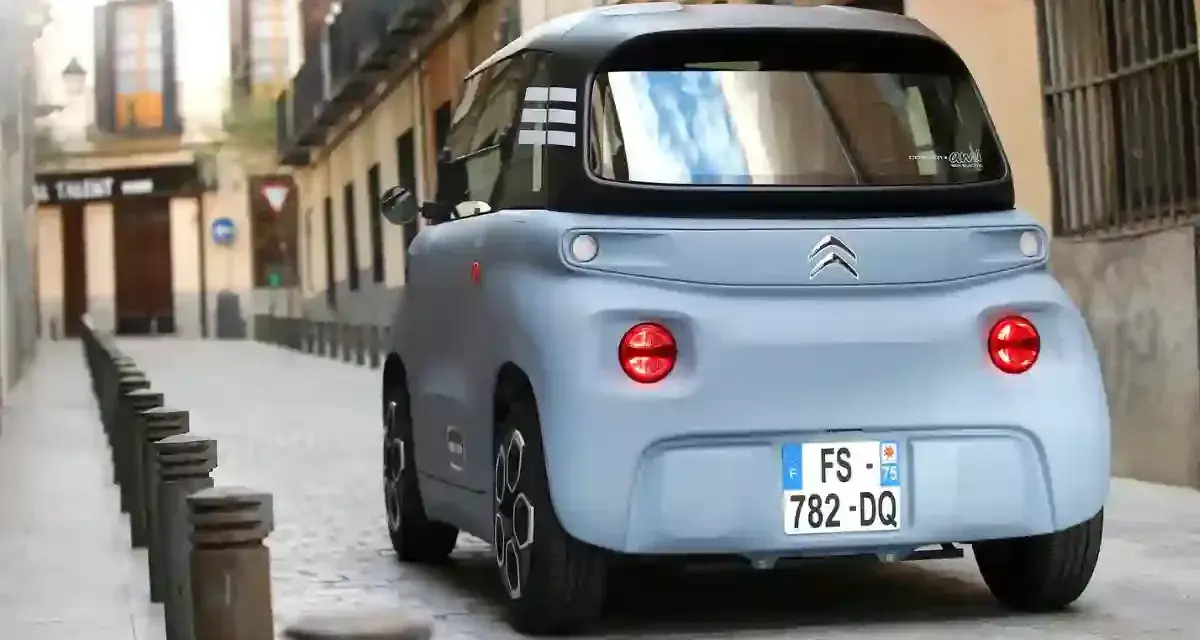 Citroën Ami bleu pastel dans une ruelle pavée. Peut-on acheter un véhicule sans contrôle technique ? Ce petit véhicule électrique est prêt à rouler.