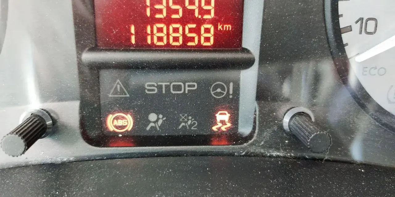Tableau de bord d'un Berlingo rouge voyant allumé : STOP, ABS, ESP. Kilométrage 118858 km.