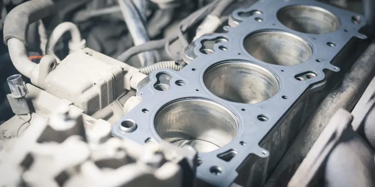 Un joint de culasse usé peut causer des symptômes inquiétants. Ici, la pièce métallique est visible sur les cylindres du moteur.