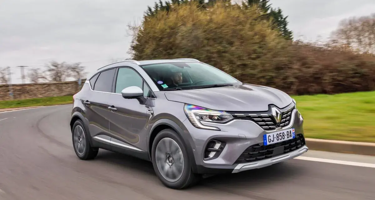 Une Renault Captur 2 grise roule sur une route sinueuse, prête pour son programme d'entretien.