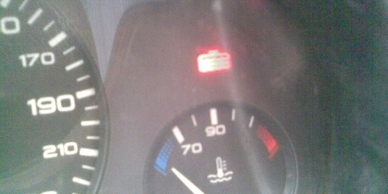 Tableau de bord d'une Peugeot 406 : voyant liquide de refroidissement allumé, aiguille de température à 70°C.