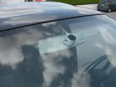 Vue intérieure d'une voiture, montrant le rétroviseur et le volant. Apprenez comment emboîter un rétroviseur intérieur pour une installation facile.