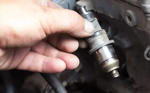 Main tenue un injecteur de carburant, possiblement en raison d'un problème d'injecteur.
