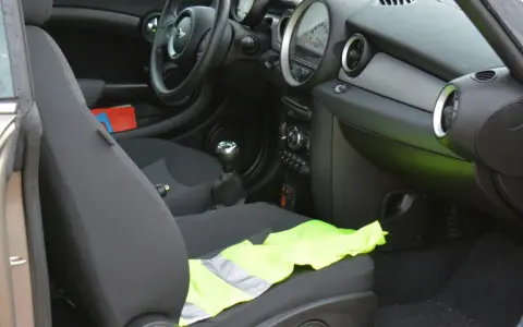 Le gilet jaune est posé sur le siège passager d'une Mini Cooper.