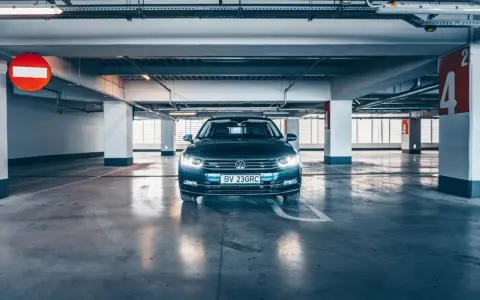 Voiture sombre garée dans un parking souterrain. La question est : combien de temps une voiture peut rester sans rouler avant de rencontrer des problèmes ?