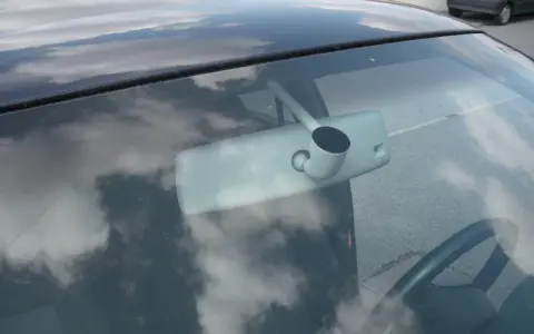 Vue intérieure d'une voiture, montrant le rétroviseur et le volant. Apprenez comment emboîter un rétroviseur intérieur pour une installation facile.