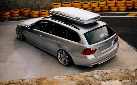 Voiture break argentée avec coffre de toit Thule, prête pour le voyage. La consommation de carburant est une préoccupation, mais le style est au rendez-vous.