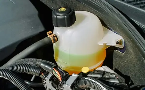Réservoir de jauge liquide de refroidissement d'une voiture, avec le liquide visible entre les marques MIN et MAX.
