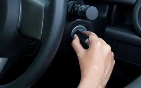 Main tenant essaie de démarrer sa voiture, mais le volant est bloqué et la clé ne tourne pas.