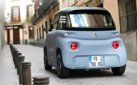 Citroën Ami bleu pastel dans une ruelle pavée. Peut-on acheter un véhicule sans contrôle technique ? Ce petit véhicule électrique est prêt à rouler.