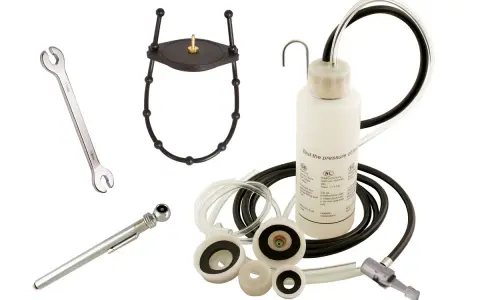 Kit pour purge embrayage hydraulique : clé, manomètre, adaptateurs et flacon de test de pression.