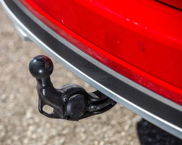 Boule d'attelage sur une voiture rouge, prête pour le remorquage.