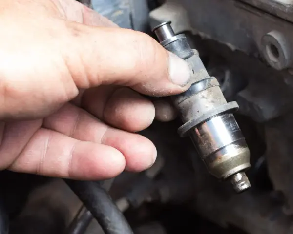 Main tenue un injecteur de carburant, possiblement en raison d'un problème d'injecteur.
