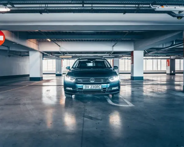 Voiture sombre garée dans un parking souterrain. La question est : combien de temps une voiture peut rester sans rouler avant de rencontrer des problèmes ?