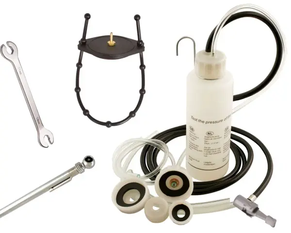 Kit pour purge embrayage hydraulique : clé, manomètre, adaptateurs et flacon de test de pression.
