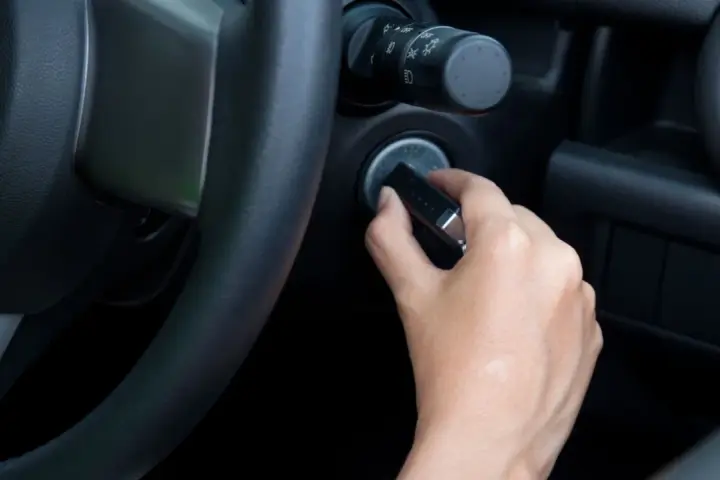 Main tenant essaie de démarrer sa voiture, mais le volant est bloqué et la clé ne tourne pas.