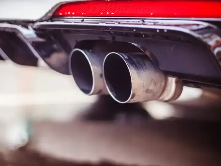 Double sortie d'échappement d'une voiture. La question "peut-on rouler avec un catalyseur défectueux" se pose face à ces gaz d'échappement.