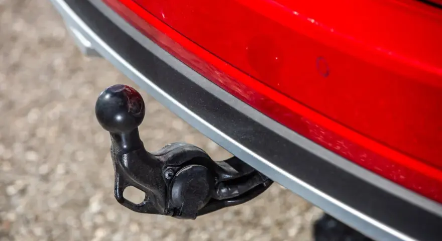 Boule d'attelage sur une voiture rouge, prête pour le remorquage.