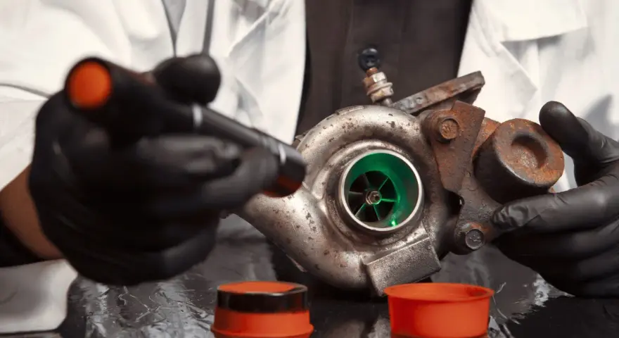 Un mécanicien examine un turbo rouillé, prêt pour le bruit turbo accélération.