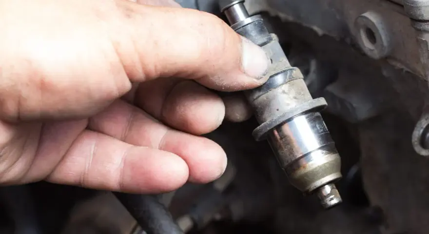 Main tenue un injecteur de carburant, possiblement en raison d'un problème d'injecteur.