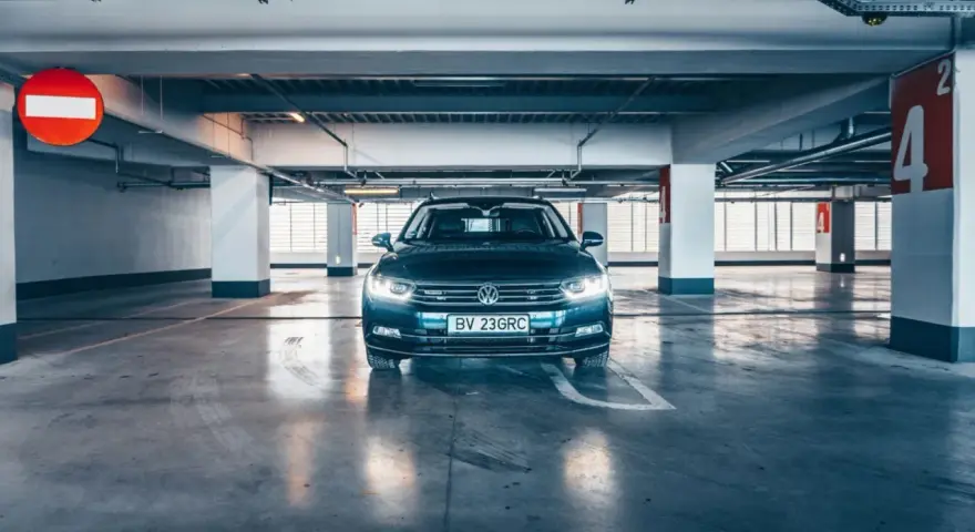 Voiture sombre garée dans un parking souterrain. La question est : combien de temps une voiture peut rester sans rouler avant de rencontrer des problèmes ?