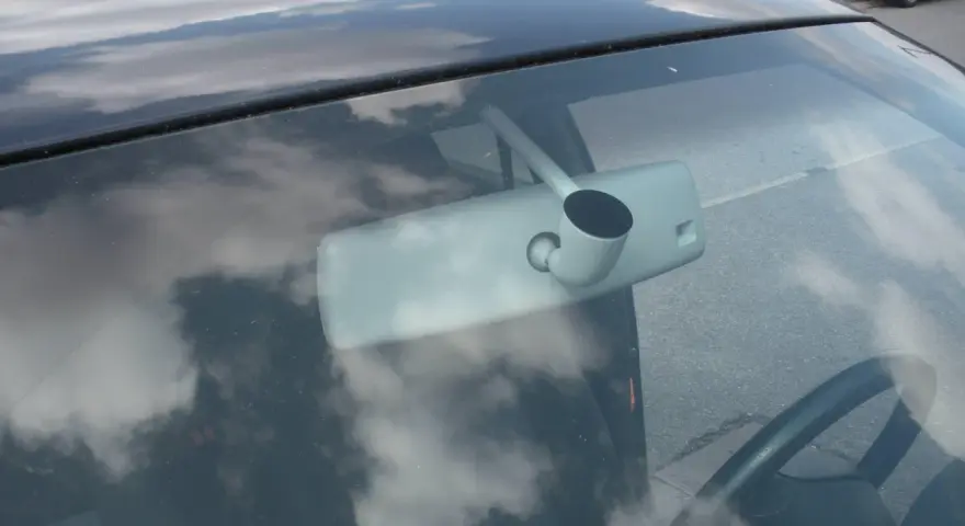 Vue intérieure d'une voiture, montrant le rétroviseur et le volant. Apprenez comment emboîter un rétroviseur intérieur pour une installation facile.