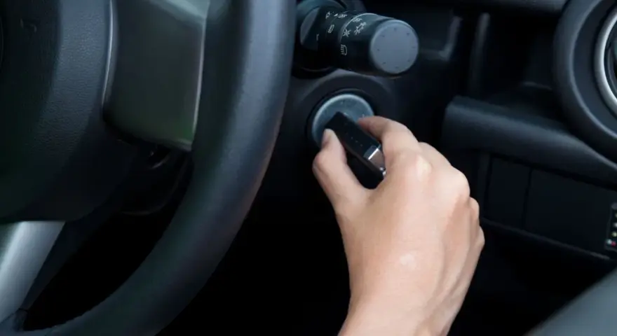 Main tenant essaie de démarrer sa voiture, mais le volant est bloqué et la clé ne tourne pas.