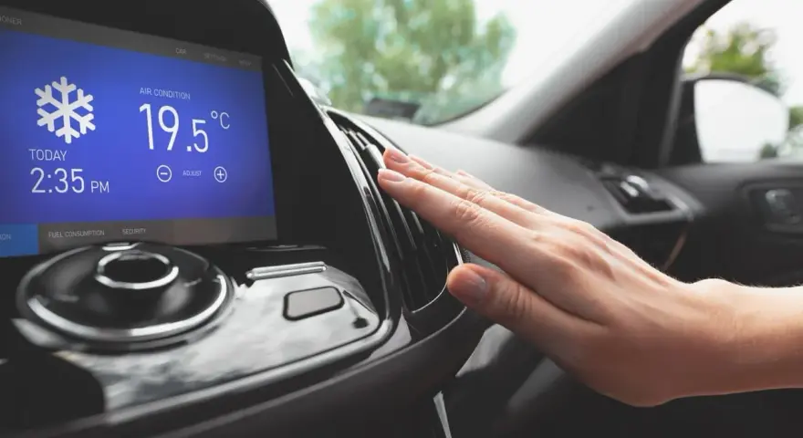 Main d'une personne vérifiant la sortie d'air climatisé dans une voiture, affichant 19.5°C. Parfait pour le clim air chaud.