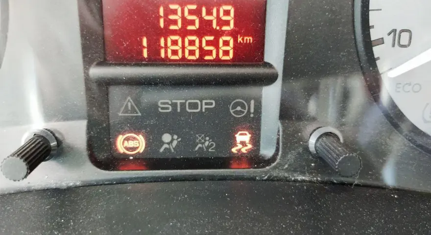 Tableau de bord d'un Berlingo rouge voyant allumé : STOP, ABS, ESP. Kilométrage 118858 km.