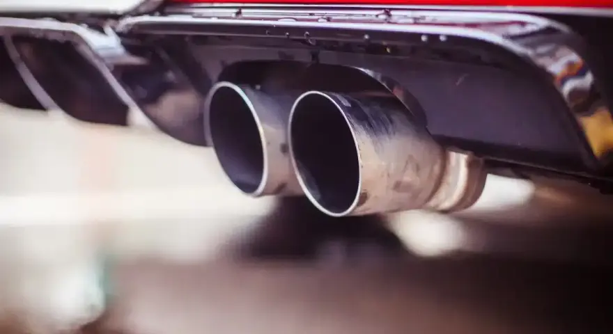 Double sortie d'échappement d'une voiture. La question "peut-on rouler avec un catalyseur défectueux" se pose face à ces gaz d'échappement.