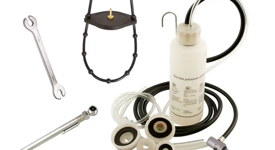 Kit pour purge embrayage hydraulique : clé, manomètre, adaptateurs et flacon de test de pression.