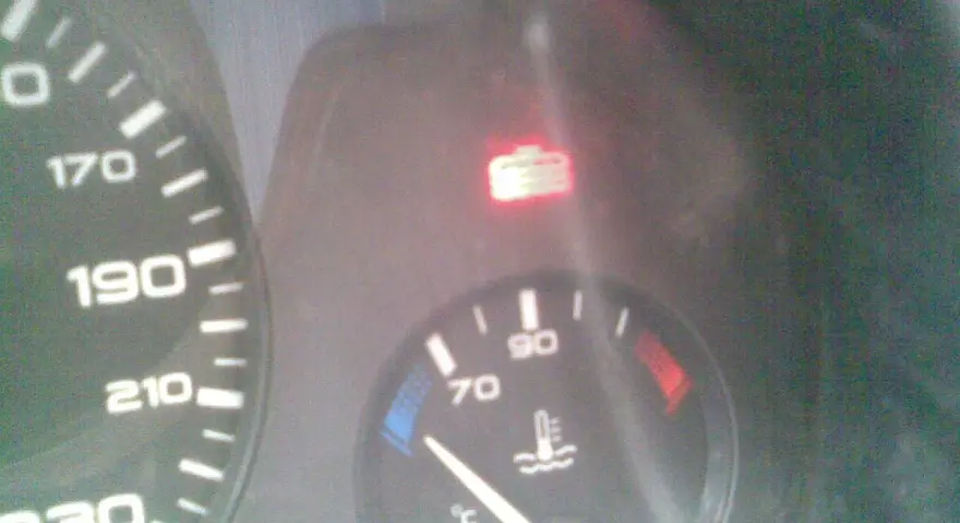 Tableau de bord d'une Peugeot 406 : voyant liquide de refroidissement allumé, aiguille de température à 70°C.