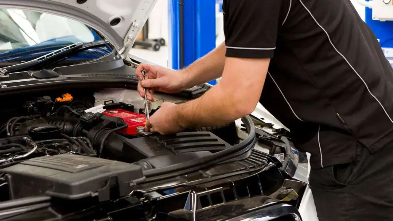M&eacute;canicien travaillant sur la batterie d'une voiture. V&eacute;rification de la dur&eacute;e de vie batterie voiture pour une performance optimale.