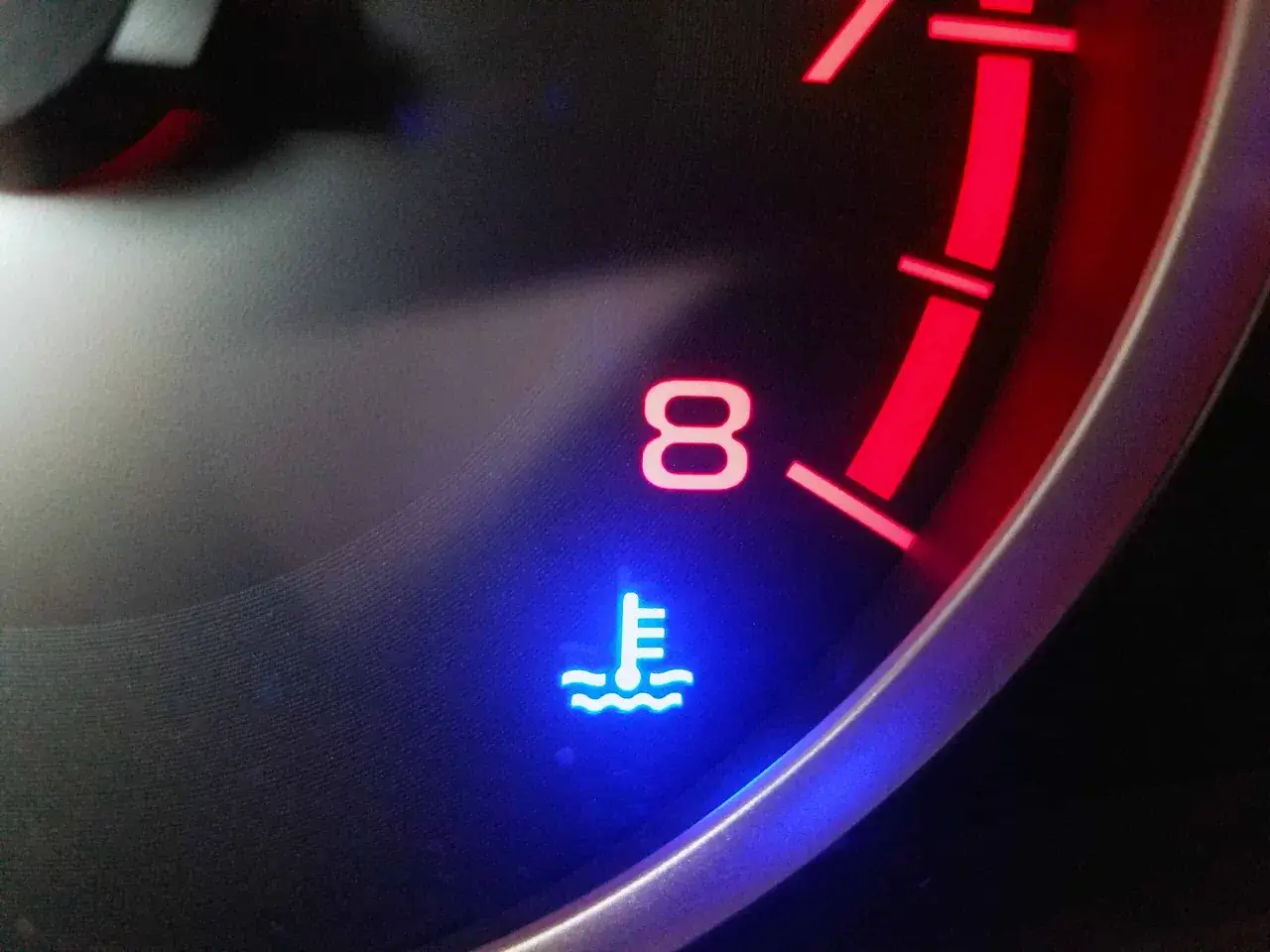 Voyant bleu de temp&eacute;rature moteur de voiture allum&eacute;, indiquant un possible probl&egrave;me de surchauffe.